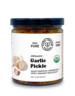 Jar of Organic Indian Garlic Pickle from Pure Indian Foods. The label claims it's a mildly garlicky, moderately spicy, insanely delicious pickled garlic achaar.
