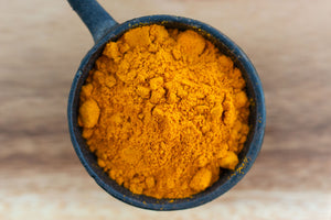 Organic lakadong turmeric powder in cast iron tadka pan