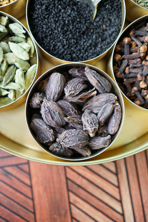 Organic Black Cardamom Pods in a brass masala dabba among other spices from Pure Indian Foods