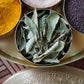 Photo of our dried curry leaves in a brass masala dabba as sold by Pure Indian Foods.