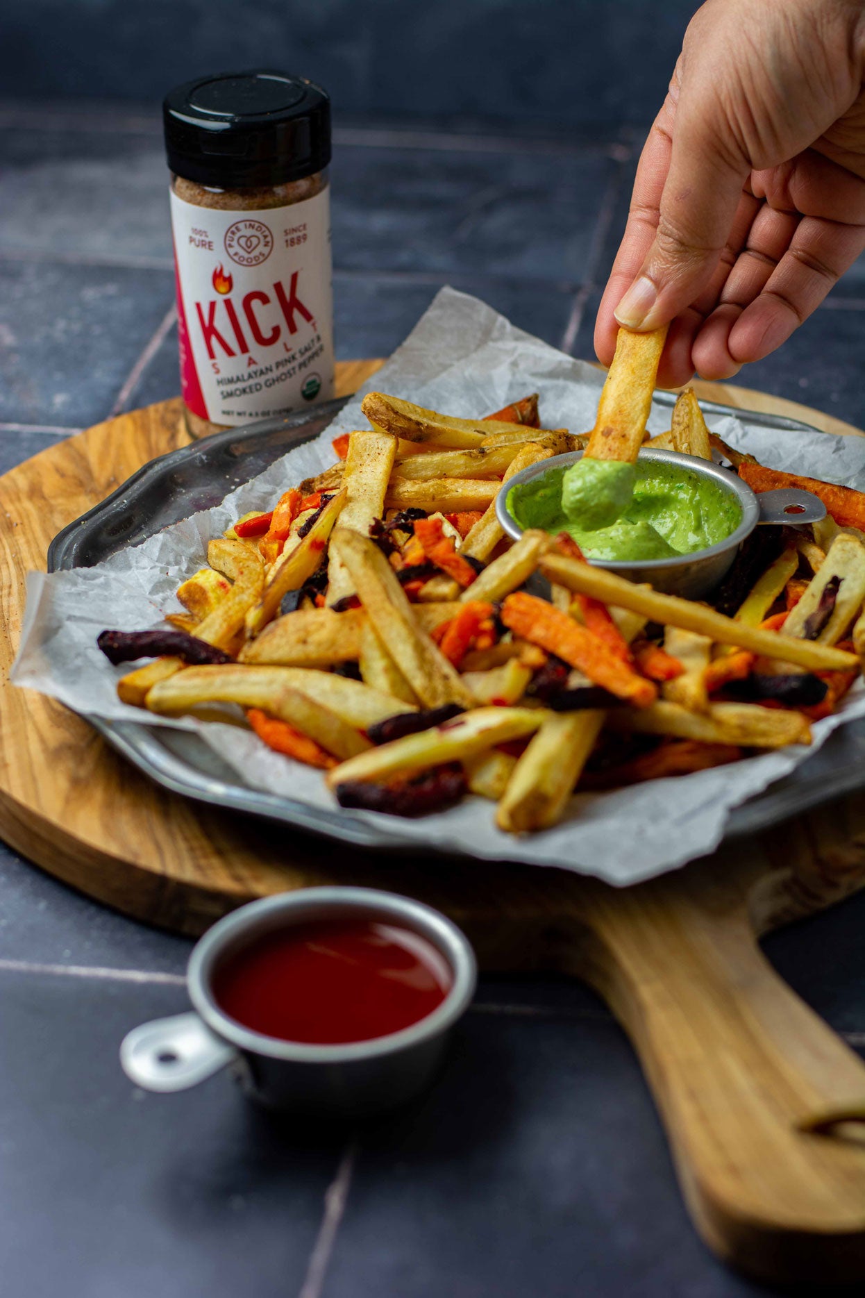 1 tray of homemade fries with dips next to a jar of KICK Salt, a blend of organic ghost pepper and Himalayan pink salt from Pure Indian Foods