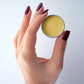 An open container of ghee lip balm made from Pure Indian Foods grass-fed ghee.