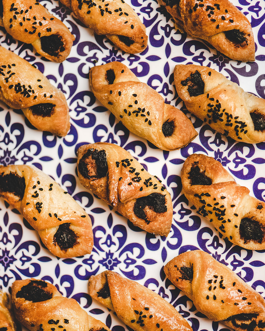 Turkish pastry filled with black olive paste and topped with organic black sesame seeds