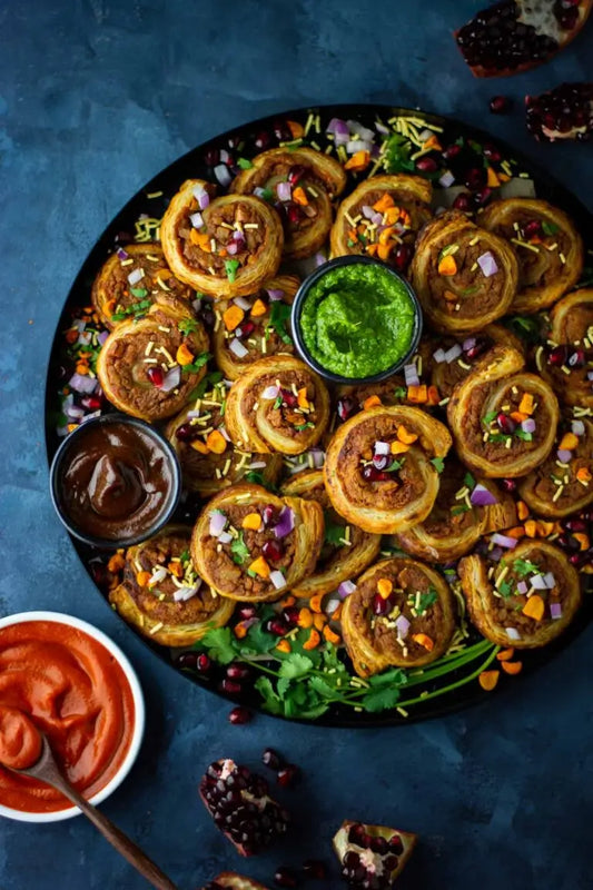 Baked dabeli (samosa pinwheels) made with Pure Indian Foods Kashmiri Red Chili Powder and served with our Tamarind Date Chutney.