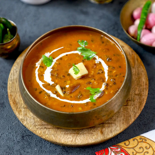 A bowl of Dal Makhani on a tray.