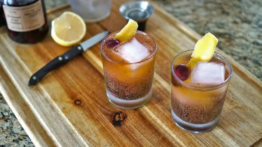 A wooden board with two tamarind Whiskey sours.