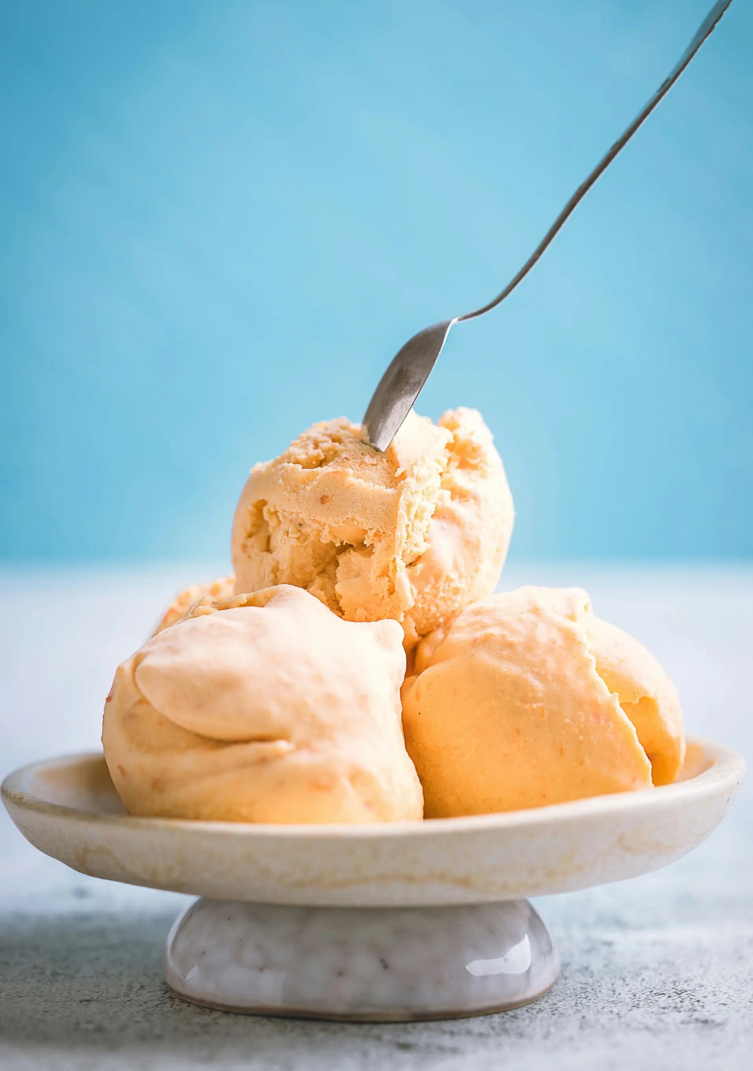 a bowl of three scoops of cardamom scented orange sherbert