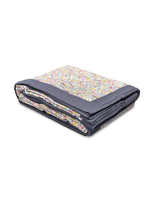 Floral patterned hand woven blanket with dark border on a white background