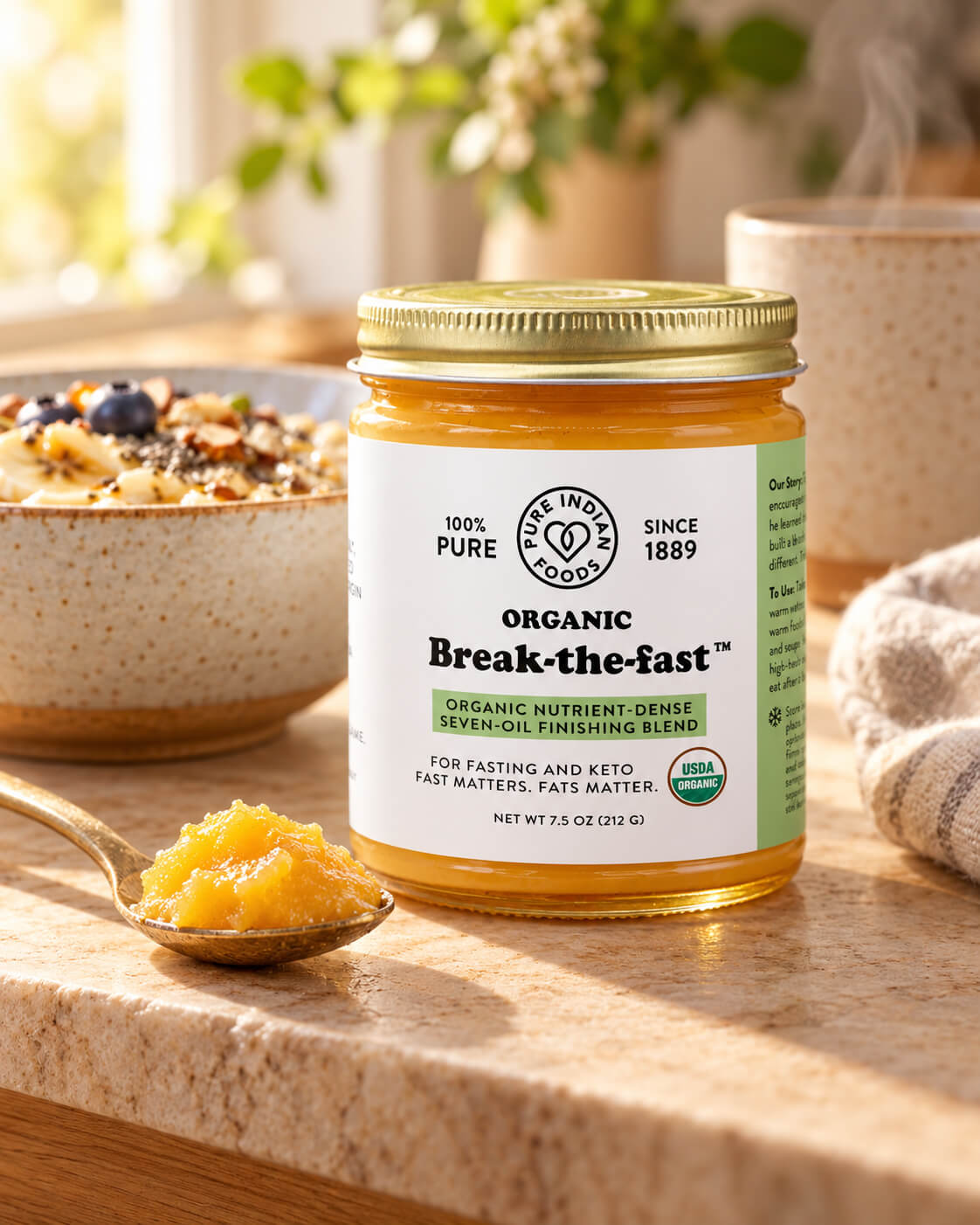 A jar of Organic Break-The-Fast nutrient dense seven oil finishing blend intended to end fasting, for keto and intermittent fasters on a kitchen counter