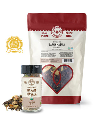 2 packages of organic whole Garam masala from Pure Indian Foods. One is an 8 oz bag, and the other is a 1.8 oz jar. They are on a white background, and an AHG Grand Prize Award badge is next to them.