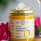 jar of organic alphonso mango puree containing 100% pure organic mango pulp displayed next to flowers