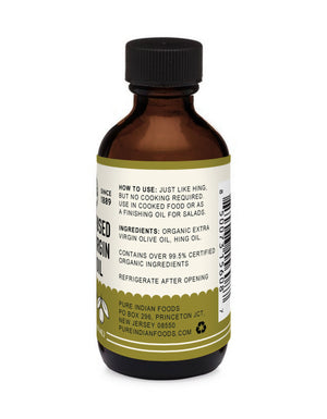 The side of a bottle of our hing infused oil with instructions for how to use it. It says to use it just like hing, but with no cooking required. Use in cooked food or as a finishing oil for salads. It also shows the ingredients as Organic Extra Virgin Olive Oil and Hing Oil. It also says it contains over 99.5% certified organic ingredients.