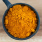 Organic lakadong turmeric powder in cast iron tadka pan