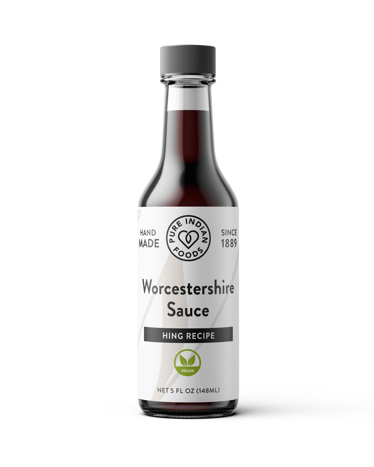 A bottle of Hing Recipe Vegan Worcestershire Sauce from the brand 'Pure Indian Foods' on a clean white background. The bottle is made of dark glass showing the dark brown sauce inside, with a white label featuring black text and a small green logo, topped with a dark gray cap.
