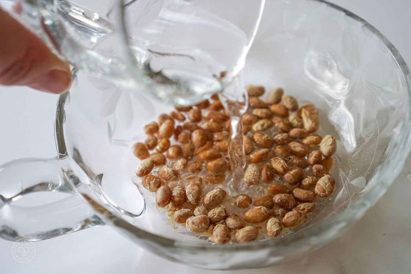 Adding water to a bowl of freeze-dried natto to begin the rehydration process and make soft natto.