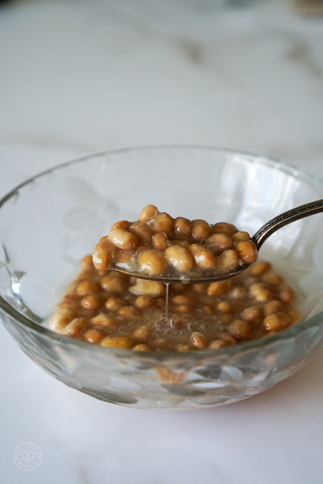 A bowl of freeze dried natto being rehydrated and stirred with a spoon.