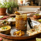 An open jar of Organic Fermented Lemon Pickle next to daal, rice, curry, and naan.