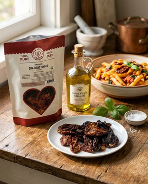 An open bag of Pure Indian Foods Organic Sundried tomatoes on a wooden table next to a bowl of prepared pasta.
