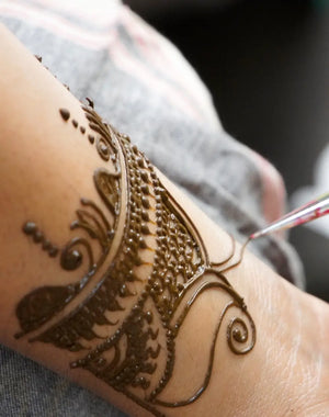 Applying pure henna powder for skin as a temporary tattoo.