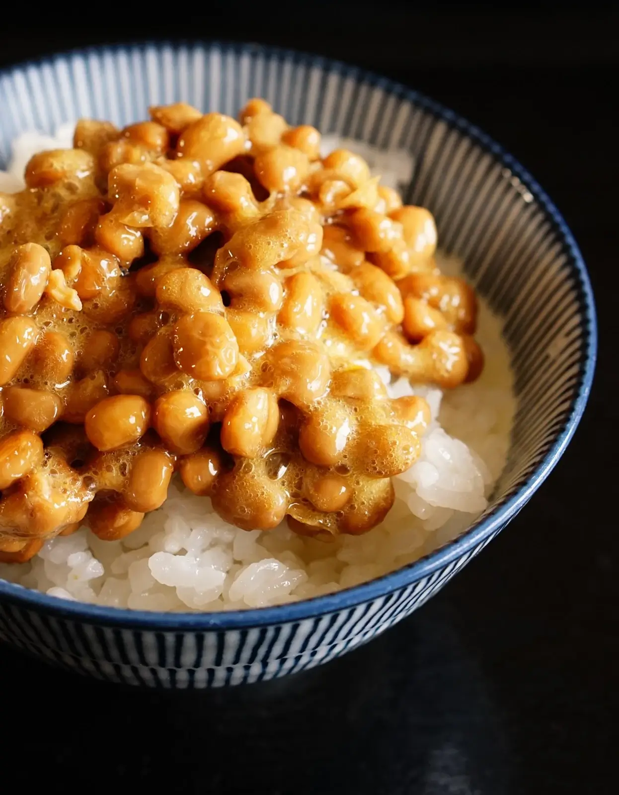 A bowl of rehydrated non-gmo natto beans served on rice.