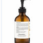 The back label on an amber bottle with a black pump of Gheek Beauty Restorative Body Oil.