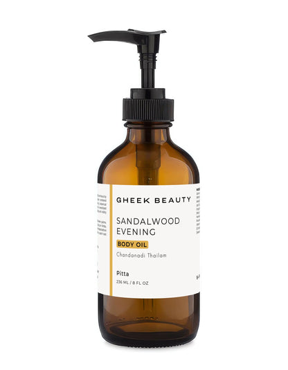 An amber glass pump bottle of Gheek Beauty Sandalwood Evening Body Oil with a black pump and a white label, shown on a plain white background.