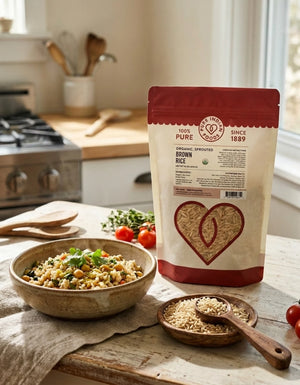 A bag of Organic Sprouted Brown Rice on a wooden table top next to a bowl of cooked rice and chickpeas