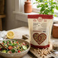 A bag of Pure Indian Foods Organic Sprouted Chickpease next to a bowl of chickpea and quinoa salad