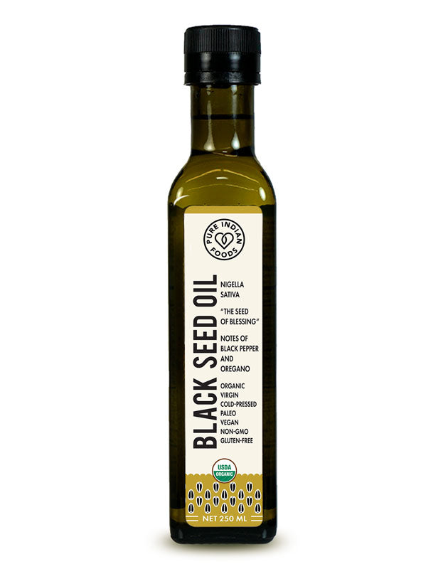 Bottle of Pure Indian Foods organic black seed oil. Label says it's extracted from Nigella Sativa, "The Seed of Blessing," with notes of black pepper and oregano. It is Organic, Virgin, Cold-pressed, Paleo, Vegan, Non-GMO, and Gluten-Free. 250ml bottle.