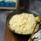 A cooked bowl of organic basmati rice from Pure Indian Foods with a package of the himalayan rice in the background.