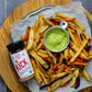 A birds eye view of a tray of homemade fries next to a jar of KICK Salt, the organic ghost pepper salt from Pure Indian Foods