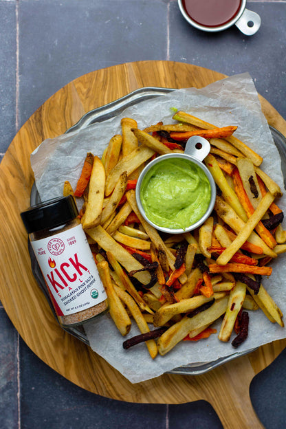 A birds eye view of a tray of homemade fries next to a jar of KICK Salt, the organic ghost pepper salt from Pure Indian Foods