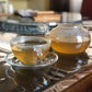 Glass teapot and teacup filled with recently brewed ayurvedic tea.