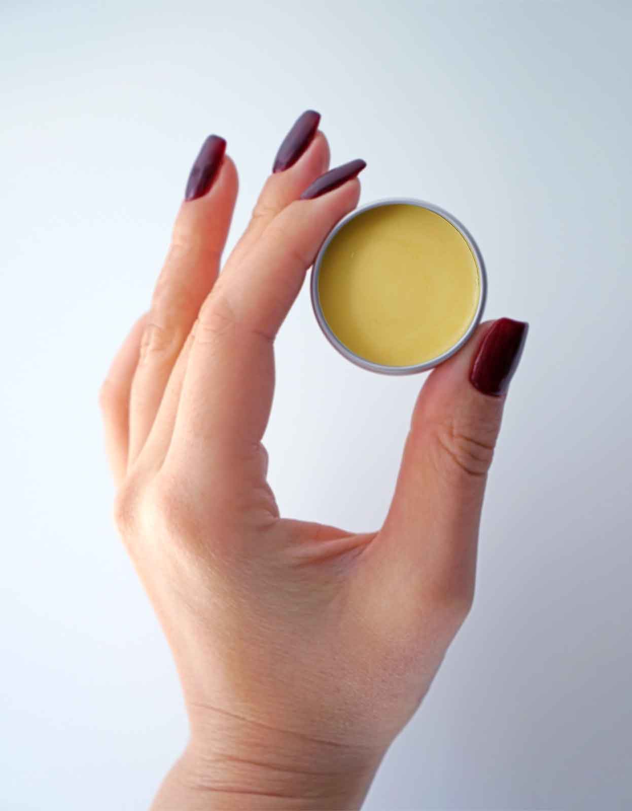 An open container of ghee lip balm made from Pure Indian Foods grass-fed ghee.