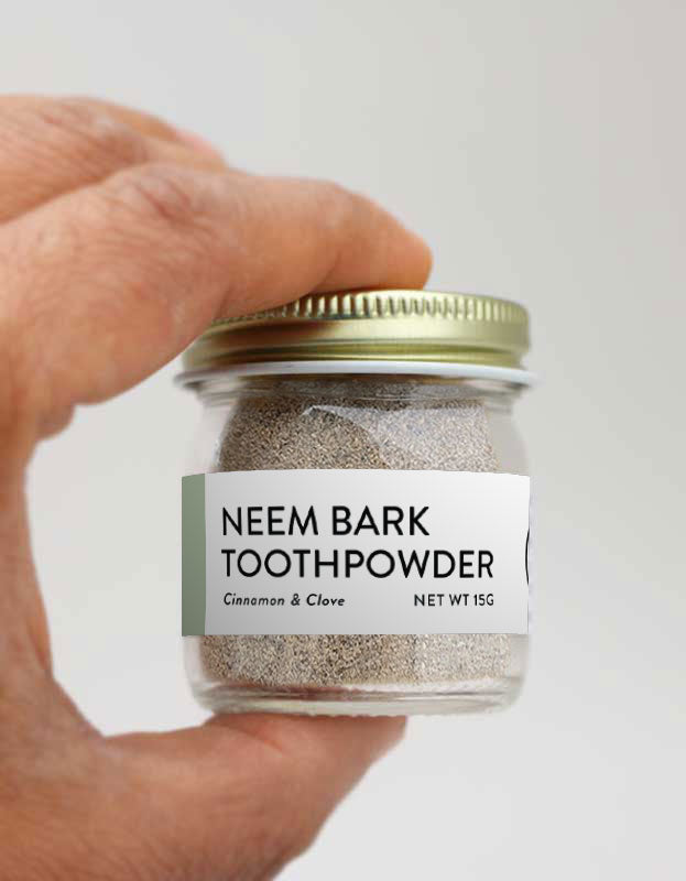 1 jare of neem bark powder with cinnamon and clove being held in someone's hand