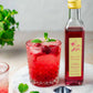 Homemade cocktail in a crystal tumbler using our organic rose simple syrup and fresh mint leaves, resting on a marble slab.