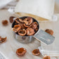 1/2 cup measuring cup full of deseeded organic soap nuts from Pure Indian Foods, pictured next to small muslin bags for laundry.