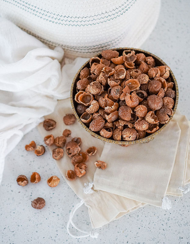 Bowl of organic soap berries from Pure Indian Foods pictured with small muslin bags for laundry.