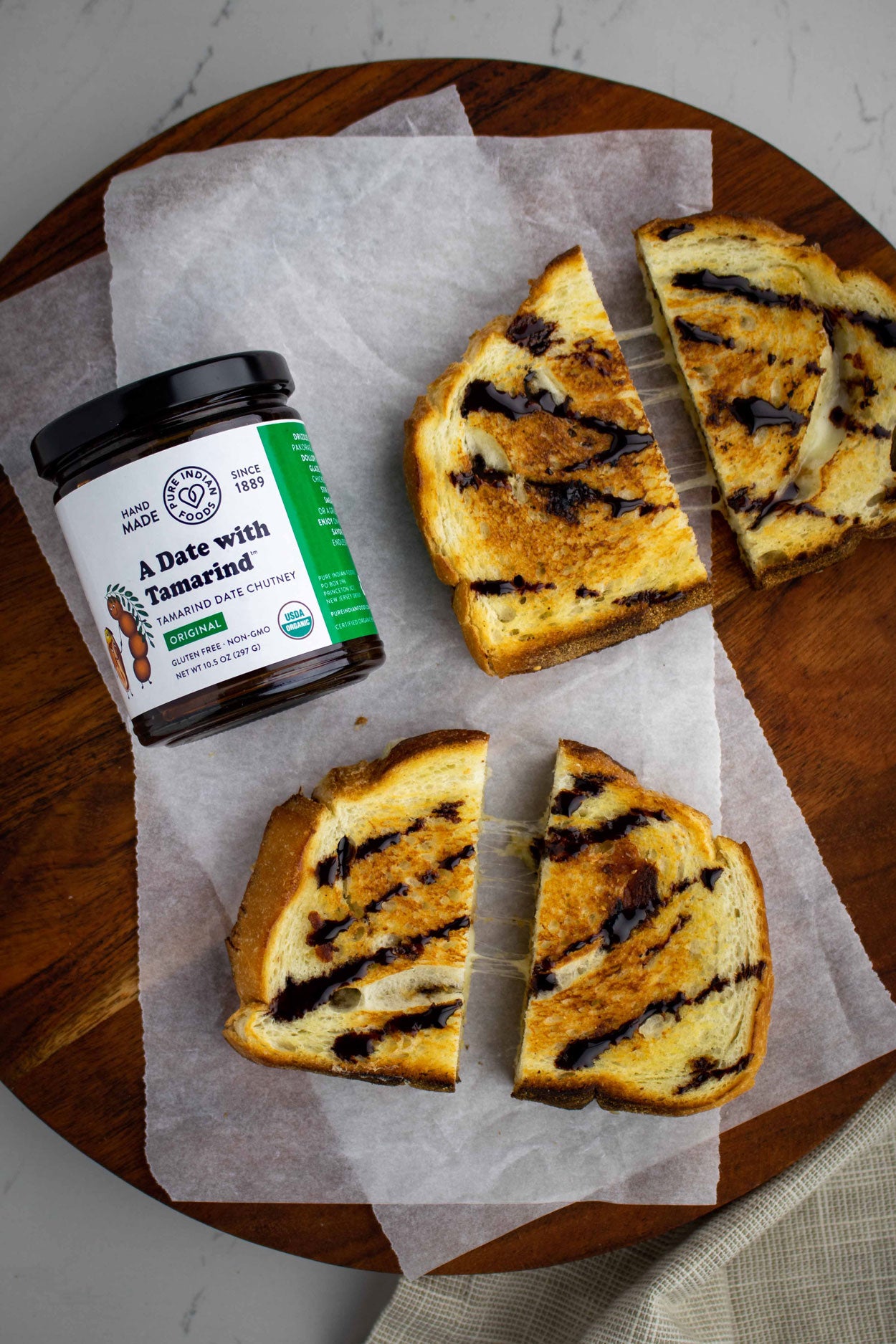 Two gooey grilled cheese sandwiches drizzled with the organic sweet tamarind chutney, also known as an imli chutney, from Pure Indian Foods