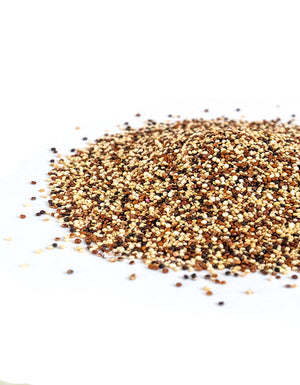 a pile of organic quinoa in a tri color mix on a white background